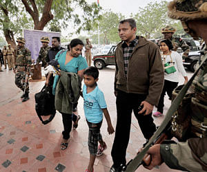 Sri Lankan military officials, Wing Commander M.S Bandara Dassanayeke and Major C.S. Harischandra Hettiarachchige with family members arrive at the airport in Coimbatore on Monday to leave for their home country in the wake of protests over their training at Defence Services Staff College at Wellington. PTI Photo