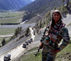 An army jawan stands guard at Amarnath Yatra route in Baltal on Sunday. PTI Photo