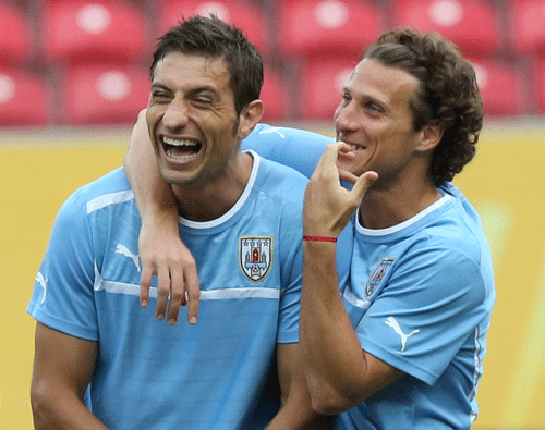 Uruguay soccer players Sebastian Eguren, left, and Diego Forlan share a joke during a training session at the soccer Confederations Cup in Recife, Brazil, Saturday, June 22, 2013. (AP Photo)