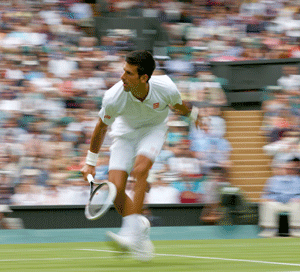 Novak Djokovic of Serbia hits a return to Florian Mayer of Germany in their men's singles tennis match at the Wimbledon Tennis Championships, in London June 25, 2013. REUTERS