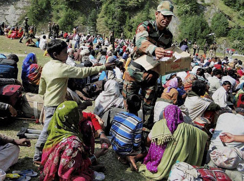 Army personnel distrubute foods among rescued pilgrims in flood-hit Uttarakhand. PTI Photo