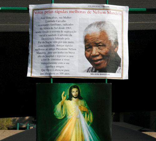 A print of Nelson Mandela and a get well card hang on the wall outside the Mediclinic Heart Hospital where former South African President Nelson Mandela is being treated in Pretoria, South Africa Wednesday, June 26, 2013. South Africa's president Jacob Zuma on Tuesday urged his compatriots to show their appreciation for Nelson Mandela, who is in critical condition in a hospital, by marking his 95th birthday next month with acts of goodness that honor the legacy of the anti-apartheid leader. (AP Photo
