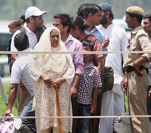 Rescued pilgrims wait for helicopter at Gauchar Airport in Uttarakhand on Thursday.PTI Photo