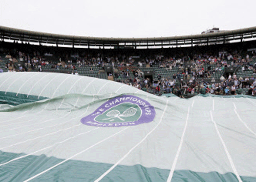 Rain covers are pulled onto Court One at the All England Lawn Tennis Championships in Wimbledon, London, Thursday, June 27, 2013. AP Photo.