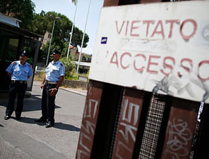 Security guards stand in front of the entrance of the courthouse in Rome June 28, 2013. Senior Vatican cleric, Monsignor Nunzio Scarano, suspected of trying to help rich friends bring millions of euros into Italy illegally was arrested on Friday as part of an investigation into the Vatican bank, police sources and his lawyer said. The banner reads 'entrance forbidden'. REUTERS