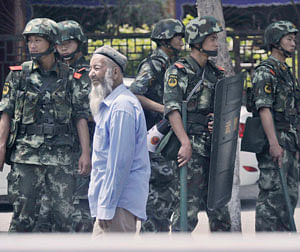 Armed police officers stand guard near the international grand bazaar in Urumqi, Xinjiang Uighur Autonomous Region, in this photo taken by Kyodo June 29, 2013. More than a hundred people, riding motorobikes and wielding knives, attacked a police station in China's ethnically divided western region of Xinjiang, state media said on Saturday, in the latest unrest to hit the restive region in the past week.  Reuters