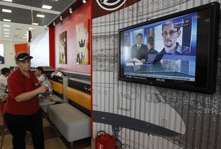 A television screens the image of former U.S. spy agency contractor Edward Snowden during a news bulletin at a cafe in Moscow's Sheremetyevo airport June 26, 2013. Reuters