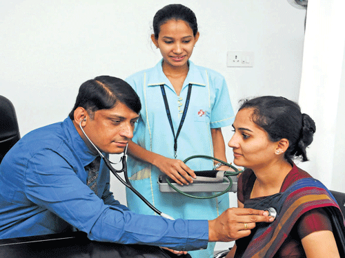 keeping faith Dr Kishore KS of Sagar Hospital in Banashankari during consultation. July 1 is observed as Doctor's Day. DH Photo by Dinesh SK