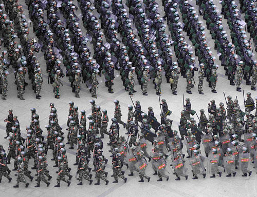 Armed paramilitary policemen run in formation during a gathering to mobilize security operations in Urumqi, Xinjiang Uighur Autonomous Region, in this photo taken by Kyodo June 29, 2013 and released in Tokyo June 30, 2013. The deadliest unrest in years in China's western region of Xinjiang was carried out by a gang engaged in 'religious extremist activities', state media reported, saying the group had been busy buying weapons and raising money. Mandatory Credit. REUTERS