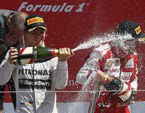 Mercedes Formula One driver Nico Rosberg (L) of Germany celebrates after winning the British Grand Prix with third placed Ferrari driver Fernando Alonso of Spain at the Silverstone Race circuit, central England, June 30, 2013. Reuters