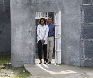 U.S. President Barack Obama and First lady Michelle Obama tour the cell block on Robben Island where Nelson Mandela was held captive near Cape Town, June 30, 2013. Obama visits a bleak former prison island off the coast of South Africa on Sunday to pay tribute to ailing anti-apartheid hero Mandela and set the stage for a speech urging Africans to strive for prosperity and democracy. REUTERS