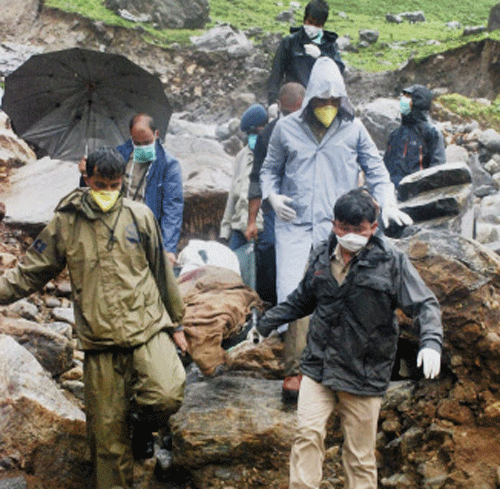 Uttarakhand police and NDRF personnel collect bodies of pilgrims from different places in Kedarnath on Sunday. PTI Photo