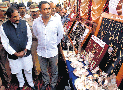 confiscated booty: Home Minister K J George and his colleague Dinesh Gundurao inspect valuables seized by police at a property parade organised at Freedom Park on Monday. kpn