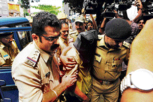 Rape accused Anand Poojary being taken to the court in Udupi on Monday. dh photo