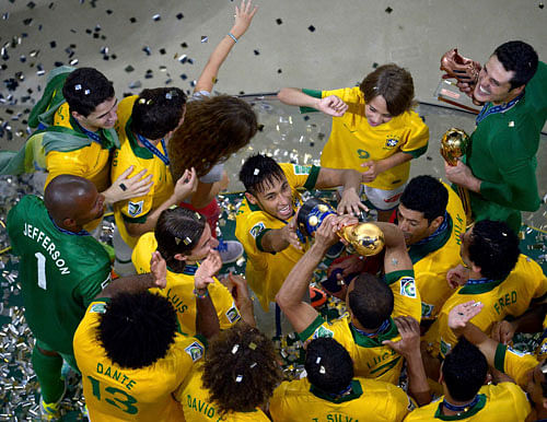 Brazil's Neymar (C) celebrates with teammates as they hold the trophy after defeating Spain in their Confederations Cup final soccer match at the Estadio Maracana in Rio de Janeiro in this June 30, 2013 handout. Picture taken June 30, 2013. REUTERS