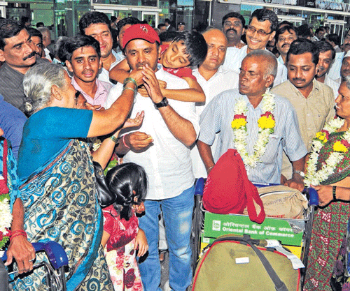 Home again: Minister for Information and rescue team in-charge Santhosh Lad is being feted by survivors who arrived in a special flight arranged by the Karnataka government at Bengaluru International Airport on Tuesday. dh photo