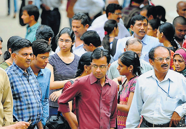 Students and their parents wait outside NMKRV college for the Comed-K counselling in Bangalore on Tuesday. DH Photo.