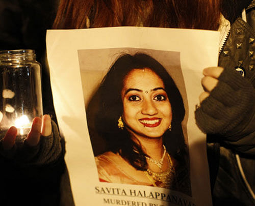 FILE - This Thursday Nov. 15, 2012 file photo shows a woman holding a picture of Savita Halappanava during a candlelit vigil outside Belfast City Hall, Northern Ireland, for Savita Halappanavar, the 31-year old Indian woman who was 17-weeks pregnant when she died of blood poisoning after suffering a miscarriage in Galway, Ireland, on 28 October. Ireland appeared on course to legalize abortion in extremely restricted circumstances as lawmakers voted Tuesday July 2, 2013 to support a bill that would permit pregnancies to be terminated when deemed necessary to save the woman's life. AP Photo