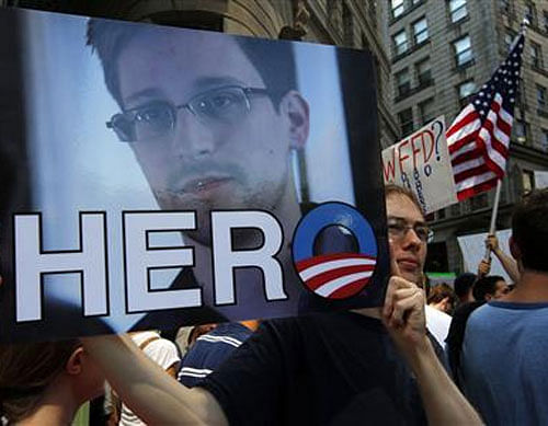 A demonstrator holds a sign with a photograph of former U.S. spy agency NSA contractor Edward Snowden and the word ''HERO'' during Fourth of July Independence Day celebrations in Boston, Massachusetts July 4, 2013.  Reuters