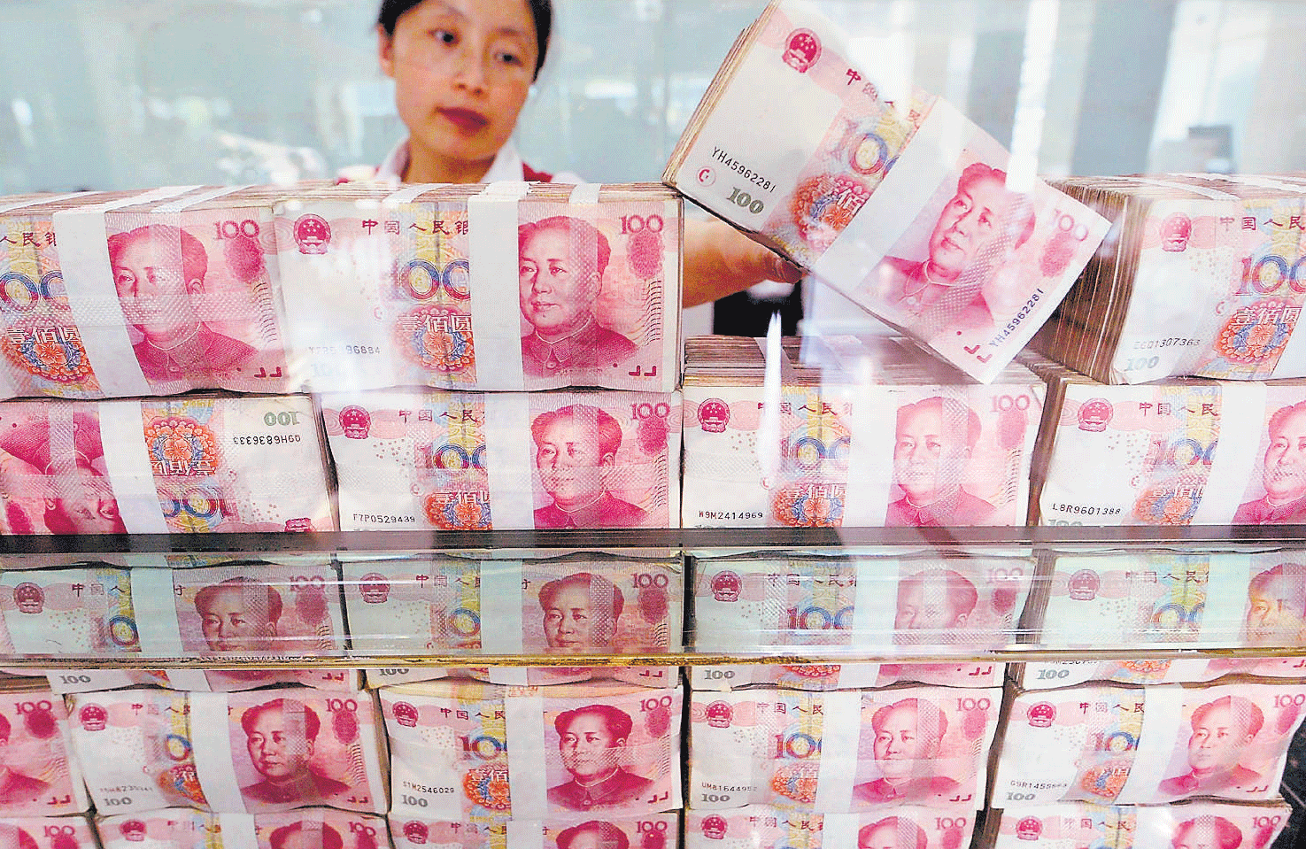 BIG WORRY: An employee counts money on the last workday of the week at a bank in Taiyuan, Shanxi province. REUTERS