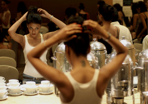 A woman applies last minute make up before going for an audition for the models for the upcoming Lakme Fashion Week, in Mumbai, India, Wednesday, July 3. 2013. The event is slated for last week of August 2013 in Mumbai. AP photo