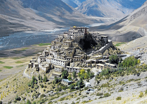 At peace (Clockwise) The Dhankar Monastery; Spiti river, surrounded by mountains; colourful prayer flags.