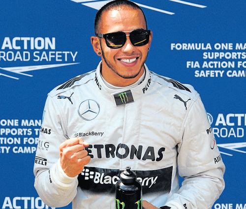 on the move: Mercedes' Lewis Hamilton celebrates his pole position on Saturday. AFP