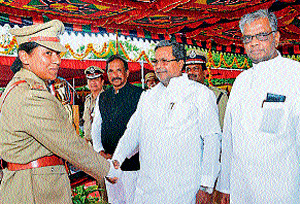 good job: Chief Minister Siddaramaiah congratulates Anupama Shenoy from Udupi, who was adjudged best in rifle shooting and secured Home Minister's trophy for best lady probationer, at the passing out parade of 31st batch of DySPs, at KPA&#8200;grounds in Mysore on Saturday. Revenue and District In-Charge Minister V&#8200;Sreenivas Prasad, Home Minister K&#8200;J&#8200;George, DG and IG&#8200;Lal Rokhuma Pachau and Director of KPA&#8200;A&#8200;S&#8200;N&#8200;Murthy are seen. DH Photo