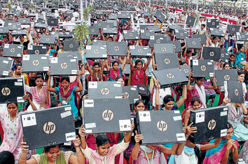 Students showing their  laptops after receiving it from Uttar Pradesh Chief  Minister Akhilesh Yadav at a function in Varanasi. PTI