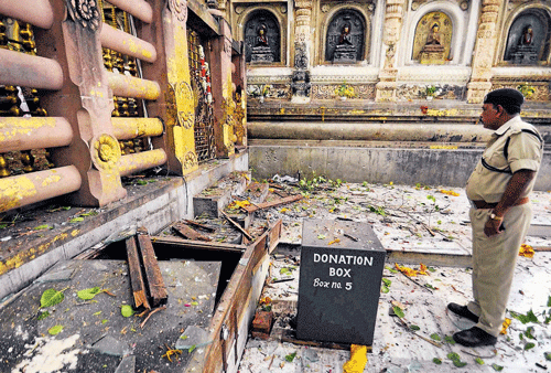 REMAINS of the day: A police officer inspects the blast site of the Bodhi tree area on the Mahabodhi temple premises  on Sunday. PTI