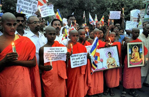 Buddhist monks take part in a candle light vigil to protest against terror attack in Bodh Gaya, in Allahabad on Sunday. A well-coordinated terror attack, nine low-intensity serial blasts targeted the world renowned pilgrimage town of Bodh Gaya and Maha Bodhi Temple complex. PTI Photo