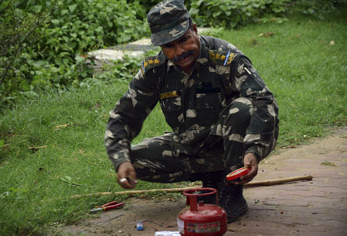 A bomb squad member defuses a suspected timer fitted device near a hotel in Bodhgaya on Sunday. AP
