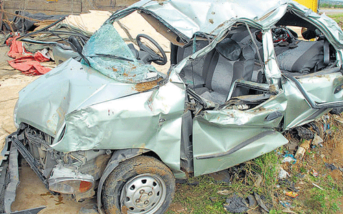 The mangled remains of the car, which collided with a lorry on NH 7, near Chikkaballapur on Tuesday.  dh photo