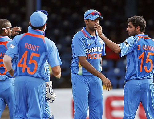 India bowler Bhuvneshwar Kumar, right, is congratulated by teammates after taking the wicket of Sri Lanka opening batsman Upul Tharanga for six runs during their Tri-Nation Series cricket match in Port-of-Spain, Trinidad, Tuesday, July 9, 2013. AP Photo