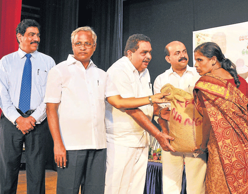 District-in-Charge Minister Ramanath Rai and MLA&#8200;J&#8200;R&#8200;Lobo hand over a bag of rice to a beneficiary during the inauguration of 'Anna Bhagya' scheme at Town Hall in Mangalore on Wednesday. MLA Mohiuddin Bava and Deputy Commissioner N&#8200;Prakash look on.