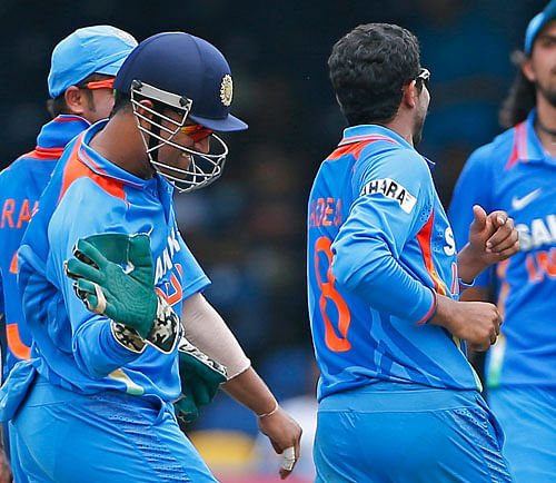 India captain Mahendra Singh Dhoni, left, congratulates teammate Ravindra Jadeja for taking the wicket of Sri Lanka's Dinesh Chandimal, who was caught by Ravichandran Ashwin for 5 runs, during the final match of the Tri-Nation cricket series in Port-of-Spain, Trinidad, Thursday, July 11, 2013. AP Photo