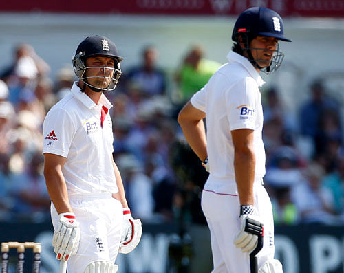 England's Jonathan Trott (L) awaits a review of his dismissal with team mate Alastair Cook during the second day of the first Ashes cricket test match against Australia at Trent Bridge cricket ground in Nottingham, central England, July 11, 2013. REUTERS