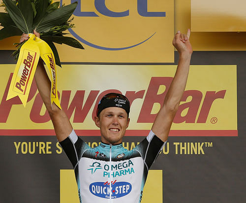 Stage winner Matteo Trentin of Italy celebrates on the podium after the fourteenth stage of the Tour de France cycling race over 191 kilometers (119.4 miles) with start in in Saint-Pourcain-sur-Sioule and finish in Lyon, central France, Saturday July 13 2013. AP Photo