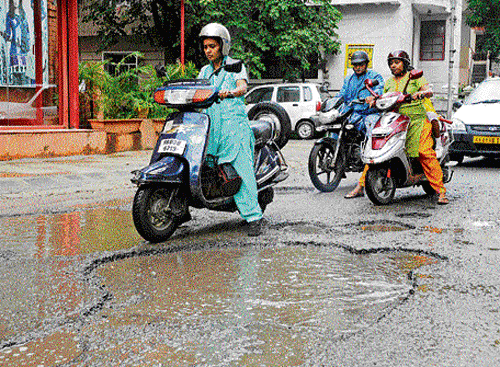puddle: Pothole-free roads in Bangalore seem a distant dream and rain only worsens the  situation. DH Photo