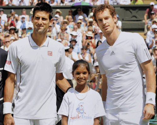 Pinki Sonkar (11), from India, poses for photographers with Andy Murray and Novak Djokovic, during the Wimbledon men's single final in London on Sunday. Pinki Sonkar, who was born with a cleft palate, strode onto Centre Court to perform the coin toss. PTI Photo