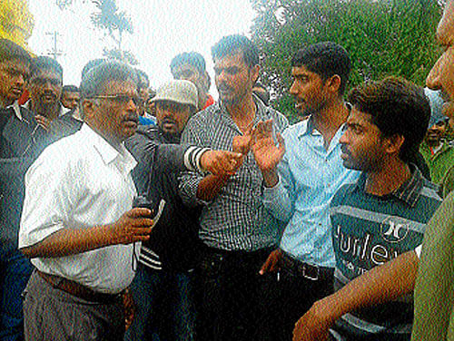 Tourists argue with department engineer Nethrapalaiah to allow vehicles inside.