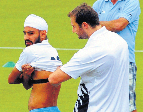 eagle-eyed: Hockey India's High Performance Director Roelant Oltmans (right) looks on as a player gets treatment from the team physio at the Sports Authority of India in Bangalore on Tuesday. PTI