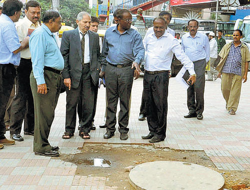 Upalokayukta S B Majage and BBMP Commissioner M Lakshminarayana inspect a manhole on Tuesday. DH photo