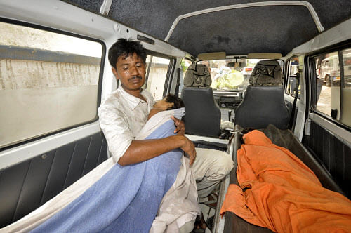 A man holds his sick child who consumed spurious meals at a school on Tuesday is brought to a hospital for treatment in Patna July 17, 2013. Reuters