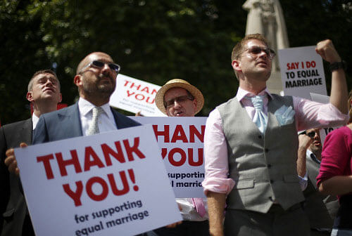 Members of the London Gay Men's Choir perform in front of the Houses of Parliament in central London July 15, 2013. Their vigil, and performances were timed to coincide with the Marriage (Same Sex Couples) Bill being read in the House of Lords today. REUTERS