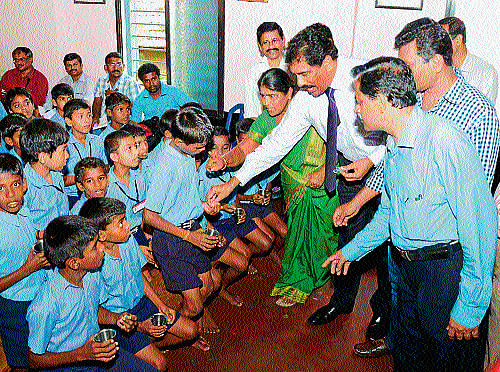 Deputy Commissioner N&#8200;Prakash distributing iron and folic acid supplement tablets to a student after inaugurating the programme at Government Higher Primary School in Attavar in Mangalore on Wednesday. DH photo