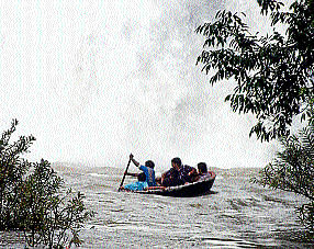 Tourists in a coracle, without life jackets, venture close to Bharachukki falls in Chamarajanagar district. DH PHOTO