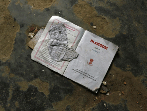 A book belonging to a second standard student lies on the floor of a classroom where contaminated meals were served to the children at a school on Tuesday at Chapra district, in the eastern Indian state of Bihar July 18, 2013. The Indian government announced on Thursday it would set up an inquiry into the quality of food given to school pupils in a nationwide free meal scheme after at least 23 children died in one of the deadliest outbreaks of mass poisoning in years. REUTERS