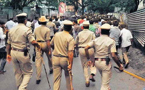 crowd control: Police chase patrons of the Adichunchanagiri Mutt, who tried to stop I-T  officers from conducting a raid on the mutt premises at Vijayanagar on Thursday. DH Photo