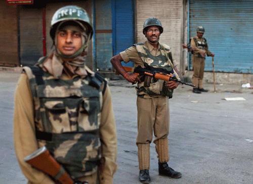 Indian paramilitary soldiers stand guard in a deserted market during curfew in Srinagar, India, Friday, July 19, 2013. Government forces in the Indian portion of Kashmir on Thursday fatally shot four villagers and wounded 25 others who were protesting the alleged desecration of the Muslim holy book by border guards, police said. AP Photo